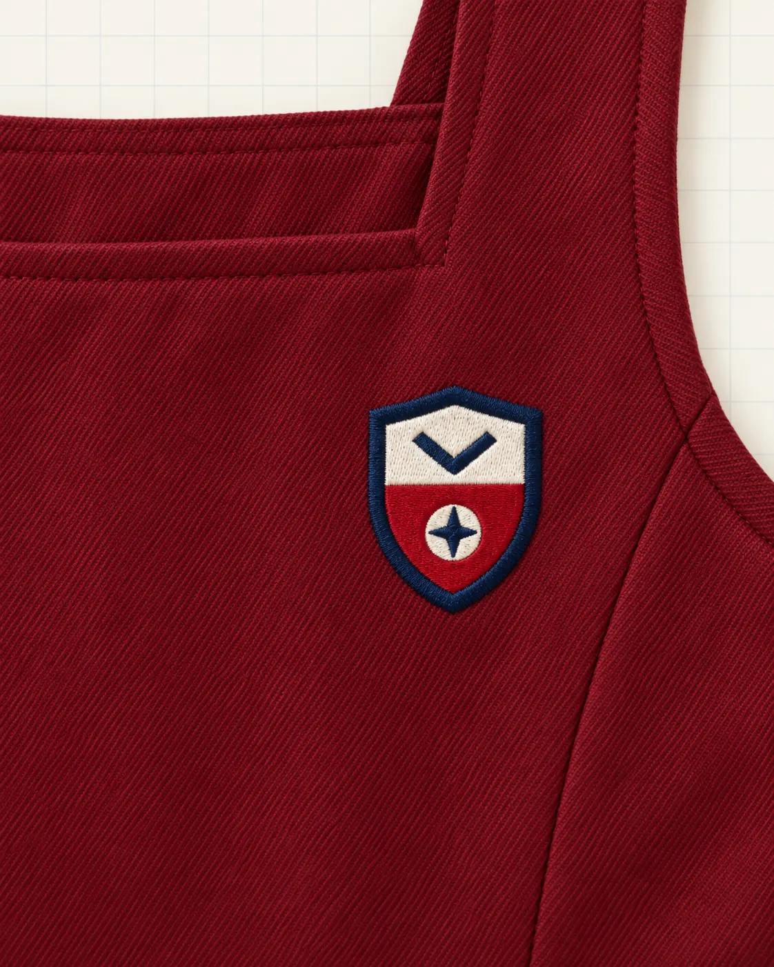 Jumper escolar rojo vino, detalle de escudo
