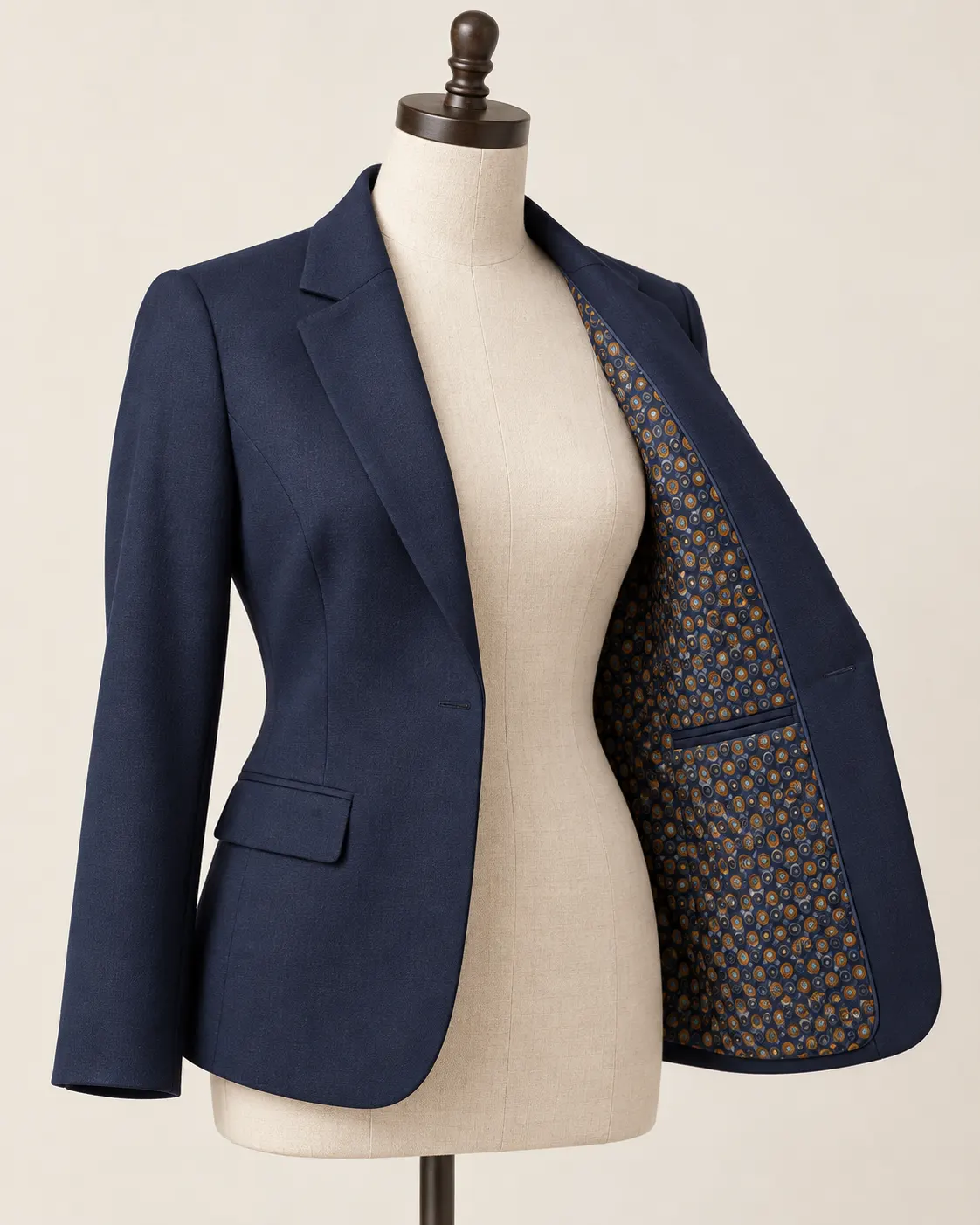 Blazer de dama azul marino abierto sobre un maniquí, con forro interior estampado de patrón geométrico